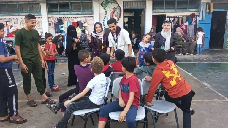 Uno scout palestinese anima gioco in un centro di accoglienza